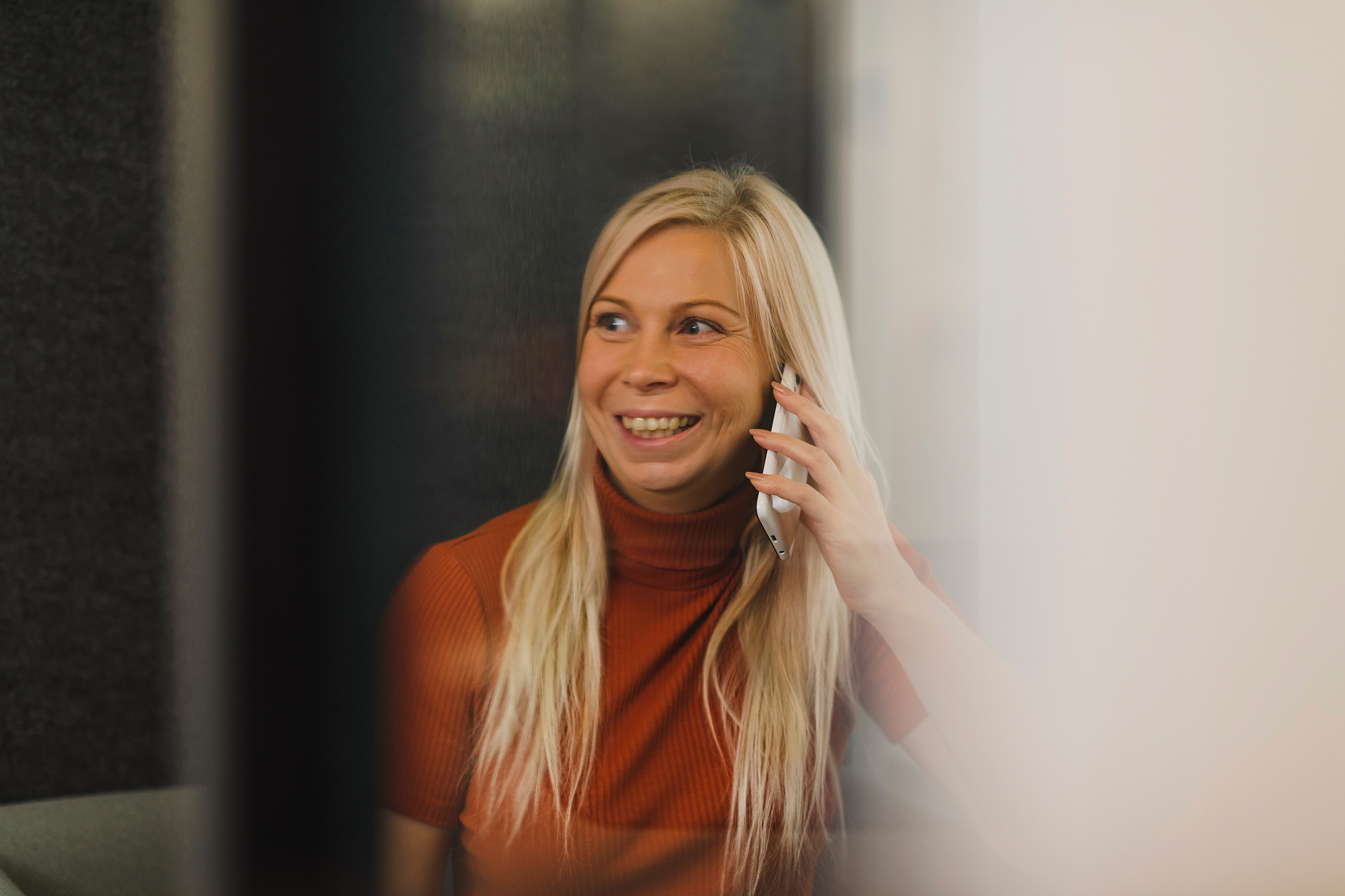 Looking in through glass on employee Petra Sahlstén while on a phone call