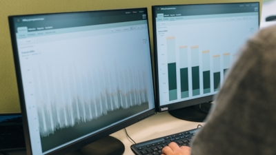 Employee looking at our customer portal on two seperate computer screens