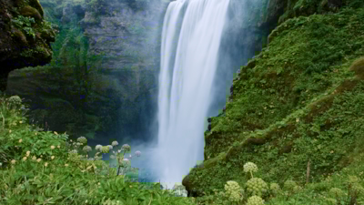 A waterfall tucked in between two green hills